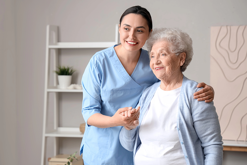 Senior woman with physical therapist hugging