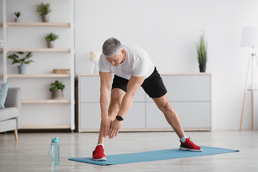 Sporty senior man stretching his legs